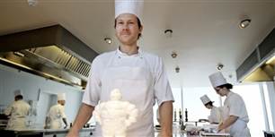 Her ses Rasmus Kofoed, køkkenchef på Geranium, som stolt står foran en figur af Michelin-manden, der har lagt navn til kokke-hæderen, der er den del af Michelin-Guiden.