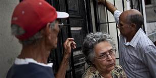 Naboer til Oswaldo Paya ses her foran hjemmet i byen Havana på Cuba, da nyheden om den kendte systemkritisker død kom frem søndag.