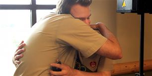 Drengespejderen Pascal Tessier får et knus af spejderleder Greg Bourke, efter at have hørt meddelelsen fra Boy Scouts of America om, at man har godkendt en resolution om at tillade spejdere, der er åbent homoseksuel i deres rækker.