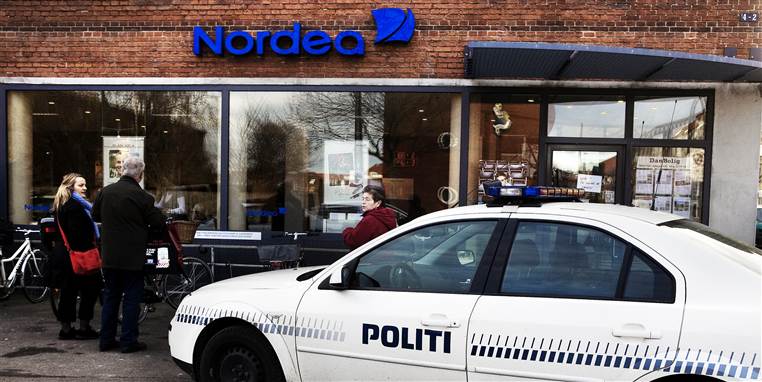Banker og tanksationer har strammet op på sikkerheden. Det øger risikoen for overfald for butiks-ansatte, der går alene i banken med omsætningen. Dette billede er dog taget efter et 'traditionelt' bankrøveri.