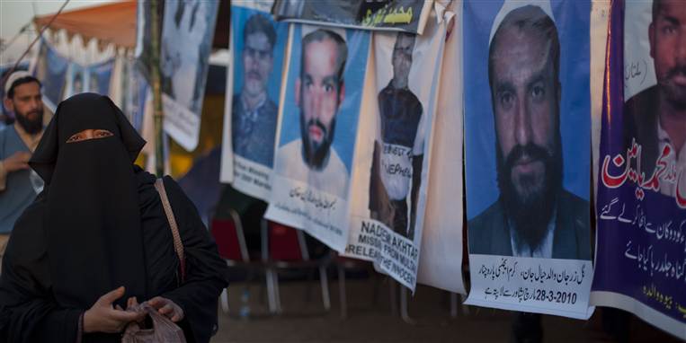 Der censureres hårdt i Pakistan og folk forsvinder. Denne kvinde går forbi plakater med fotos af forsvundne mænd. Familier har nu fået lov til at føre sag ved Højesteret imod sikkerhedstjenesten ISI, der anklages for ansvarlighed.