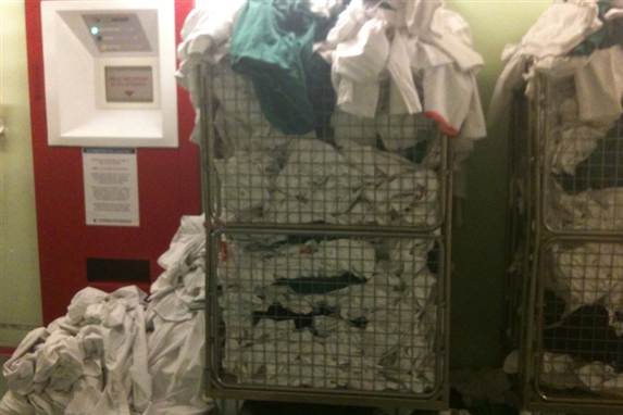 Vasketøj hober sig op ved den nye uniformsautomat på Herlev Hospital.