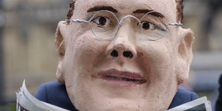 En mand iført en maske lignende James Murdoch, søn af Rupert Murdoch.