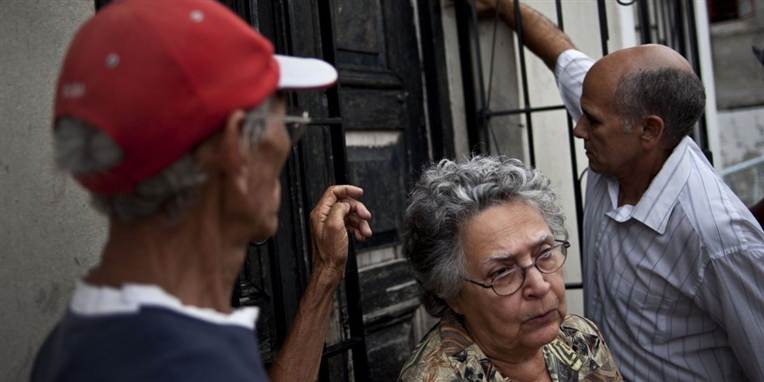 Naboer til Oswaldo Paya ses her foran hjemmet i byen Havana på Cuba, da nyheden om den kendte systemkritisker død kom frem søndag.