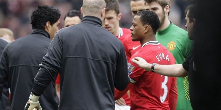 Evra forsøger forgæves at give Suarez hånden.
