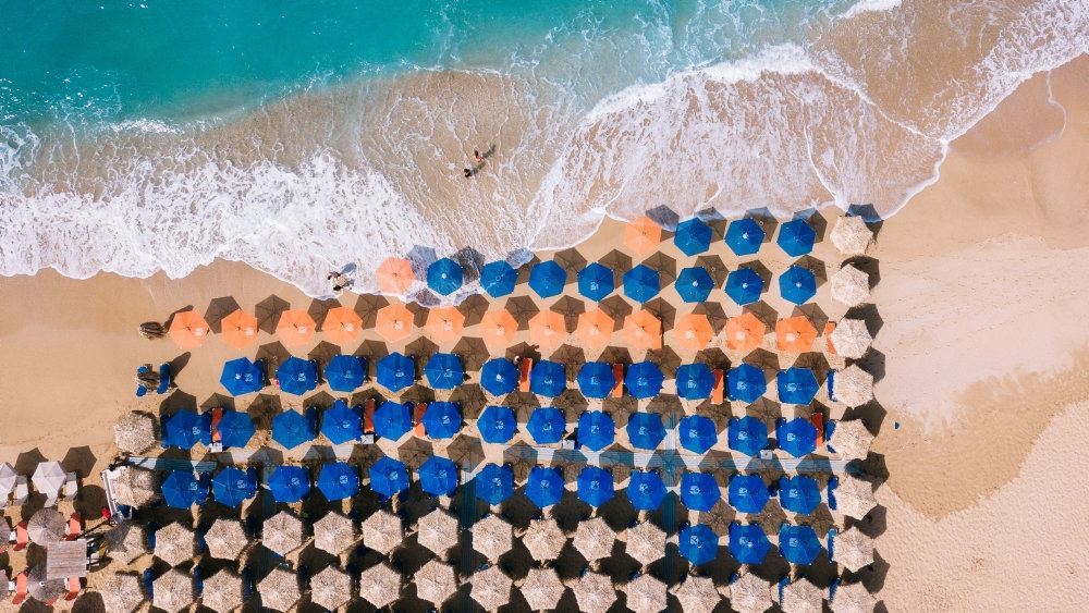 parasoller på strand set fra luften