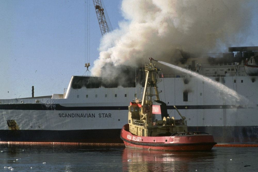 Scandinavian Star brænder mens et slukningsfartøj sprøjter vand op på det