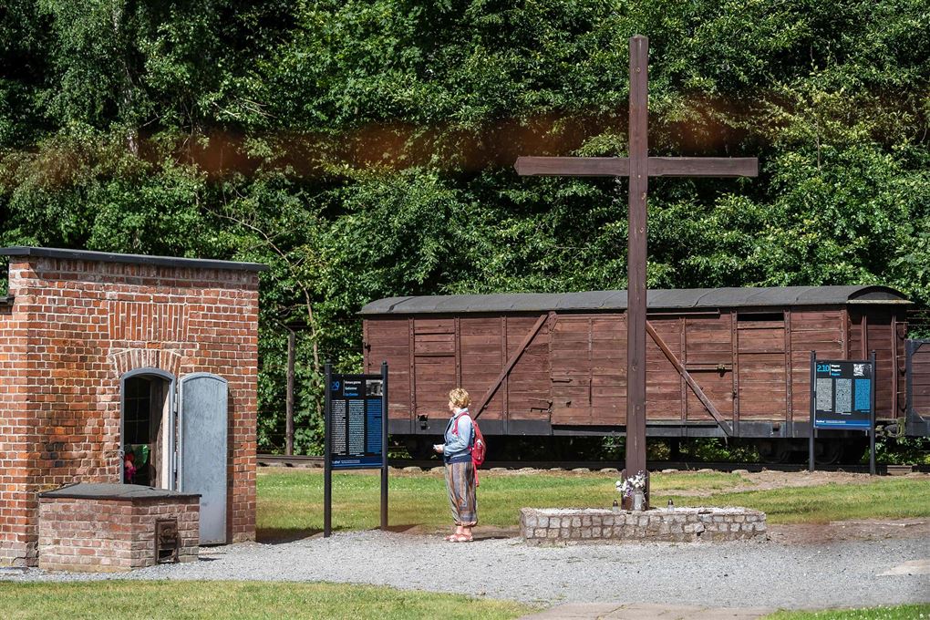 En kvinde står foran indgangen til gaskamrene i KZ-lejren Stutthof. 