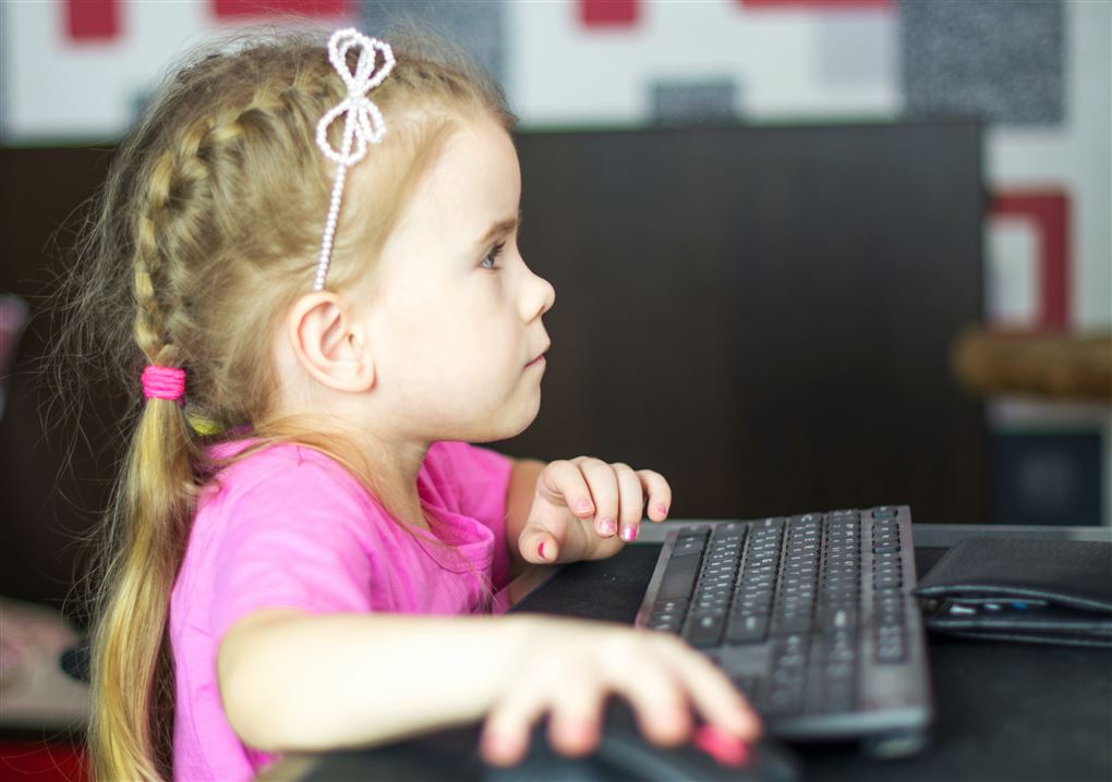 En lille pige ved en computer