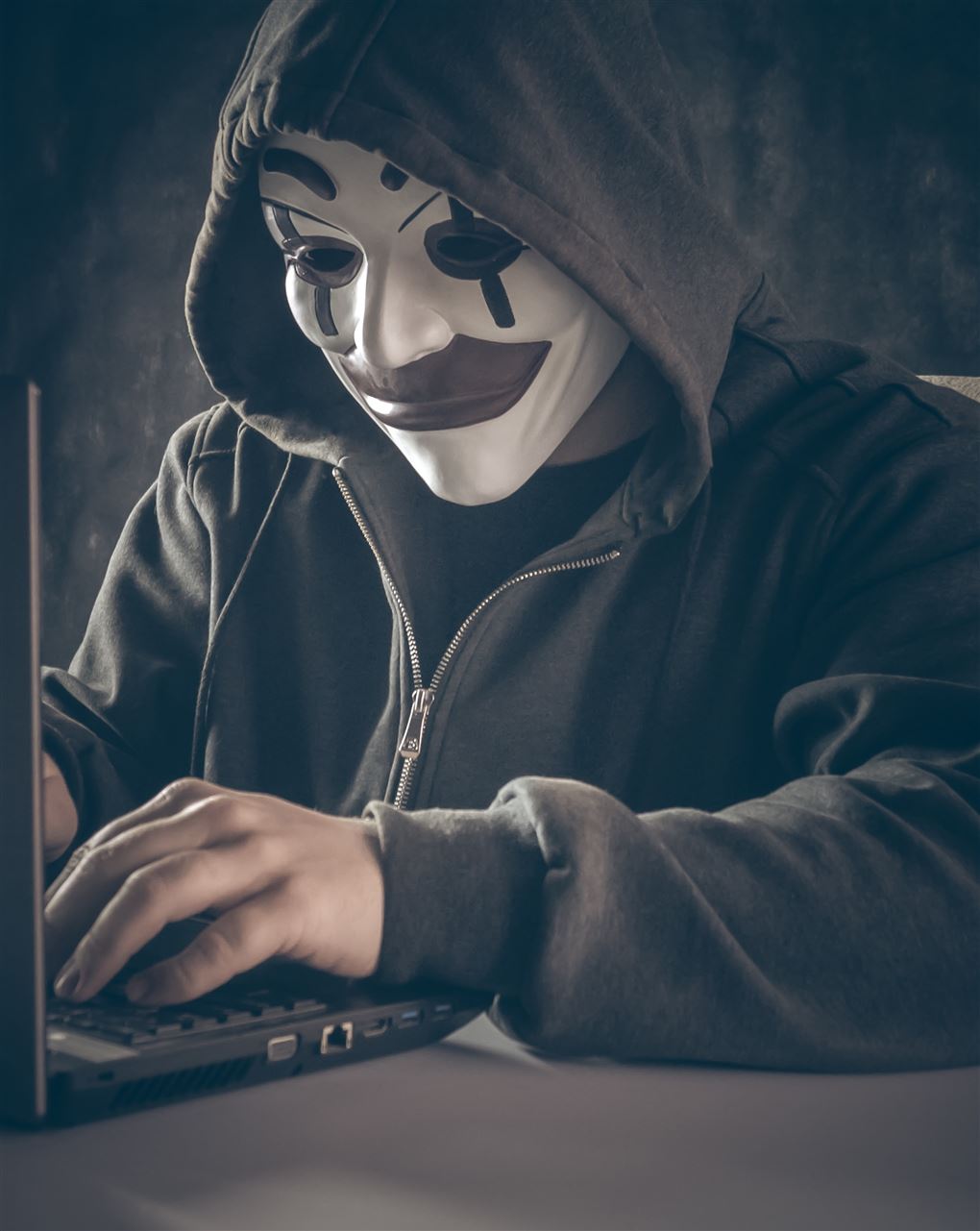 En maskeret person ved en computer