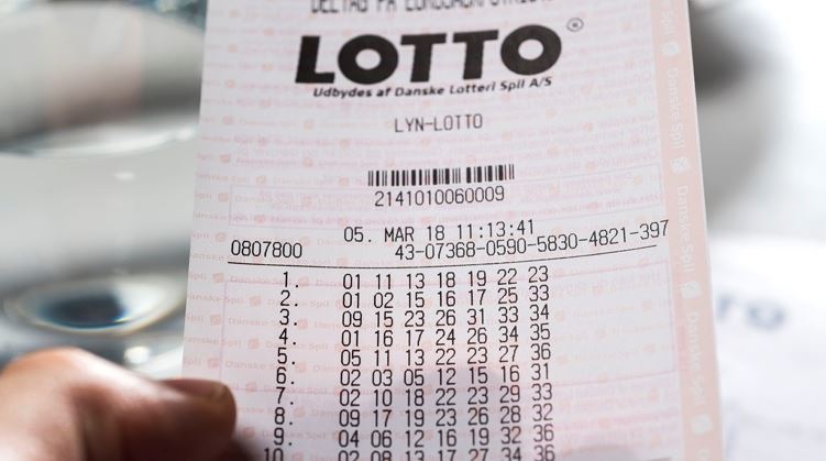 person holder lottokupon i hånden