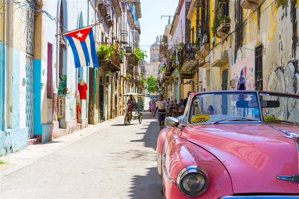 en gammel pink Chevrolet cabriolet i en gade på Cuba