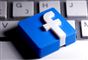 3D-printet facebook-logo ligger på keyboard