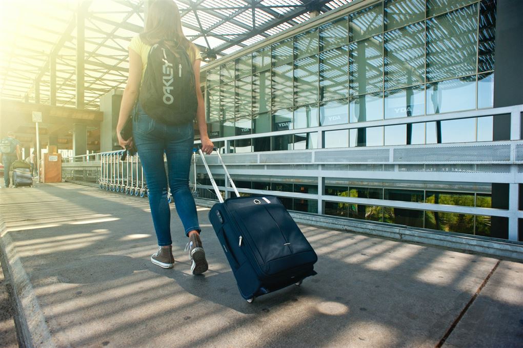 Kvinde med kuffert ved lufthavn