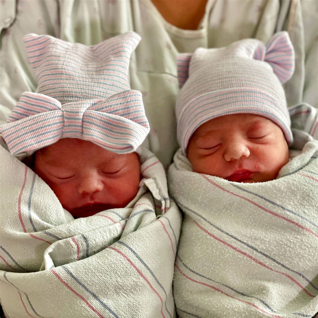 nyfødte tvillinger ligger i vugge