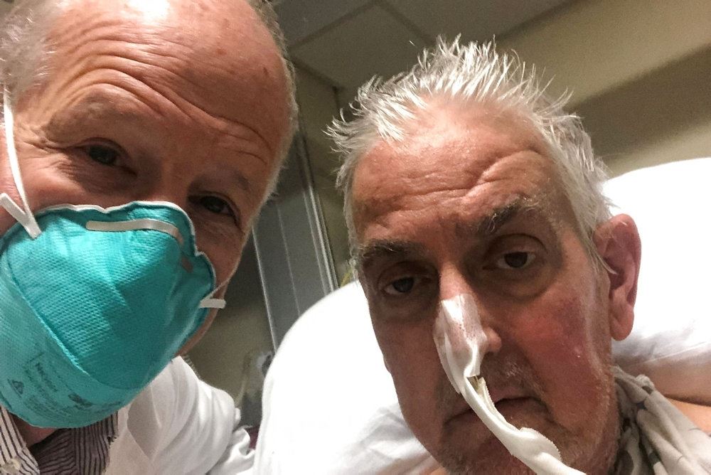 David Bennett med en iltslange i næsen og en læge ved siden af. Det ligner et selfie billede