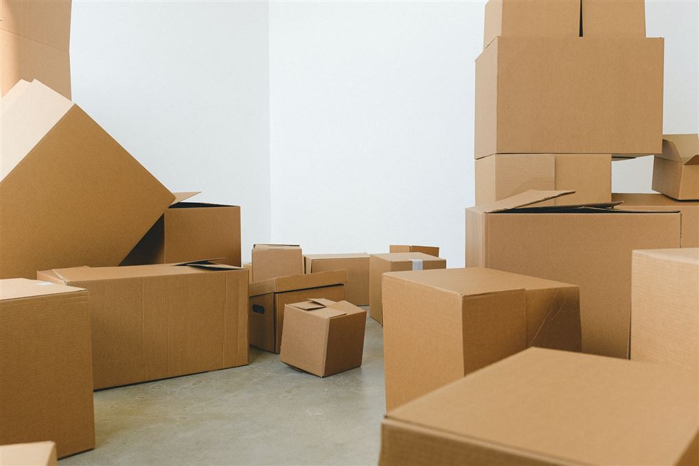En bunke papkasser i et rum