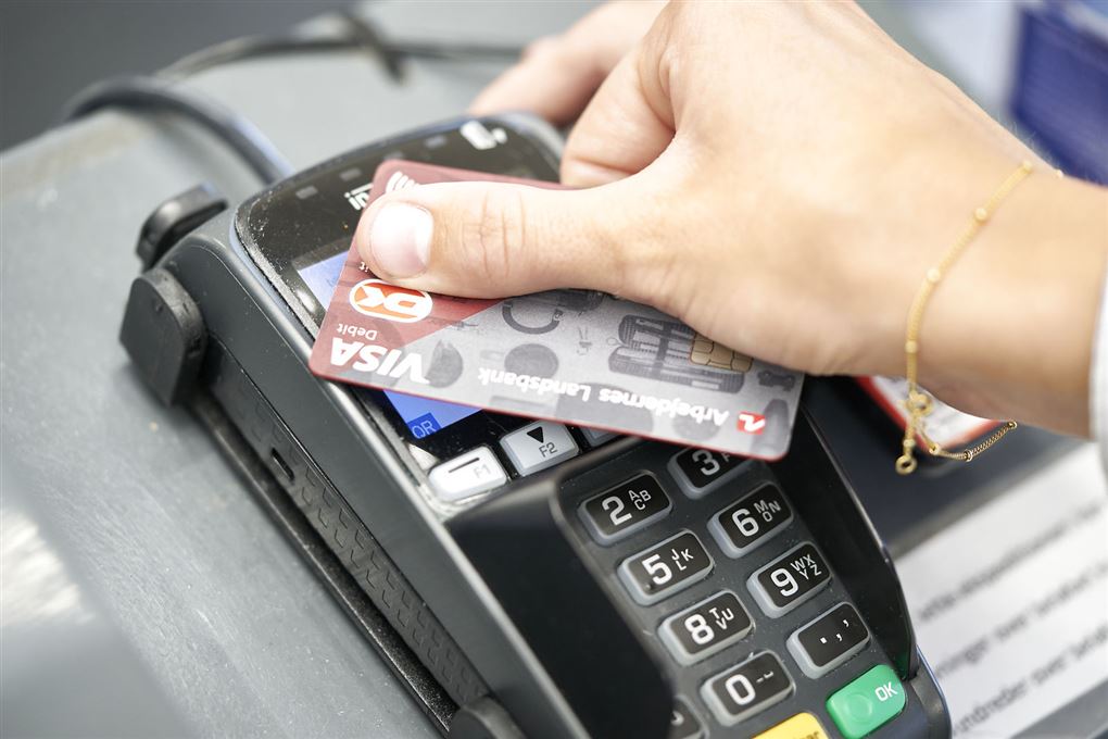 person holder kreditkort over terminal