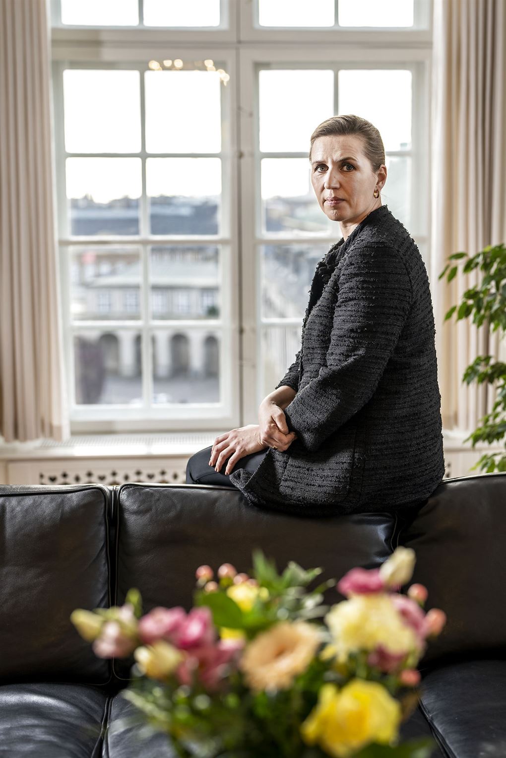 Mette Frederiksen på kanten af en sofa i sit kontor