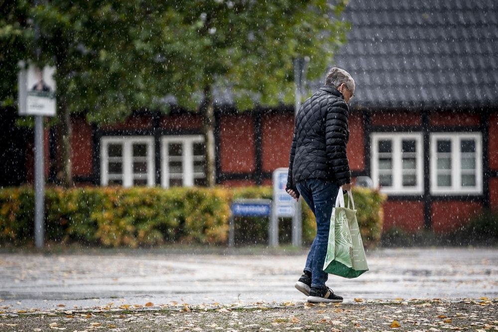 person med pose går i regnvejr