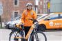 person i orange tøj står ved elcykel 
