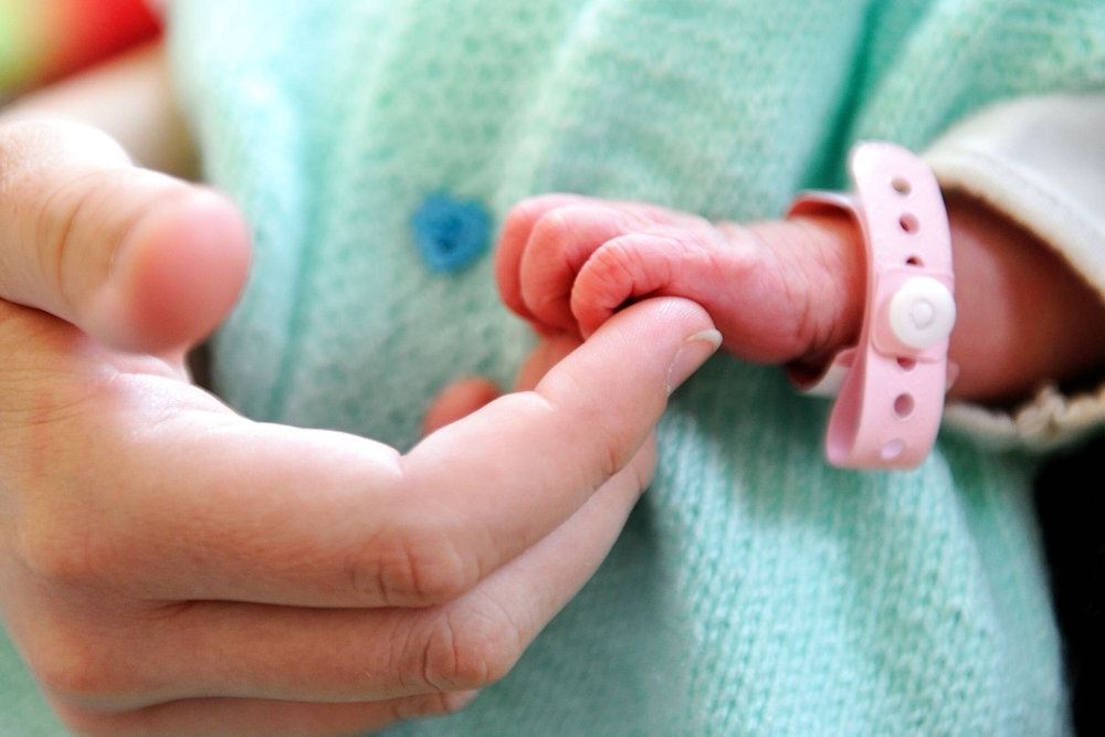 En baby holder i en voksens finger