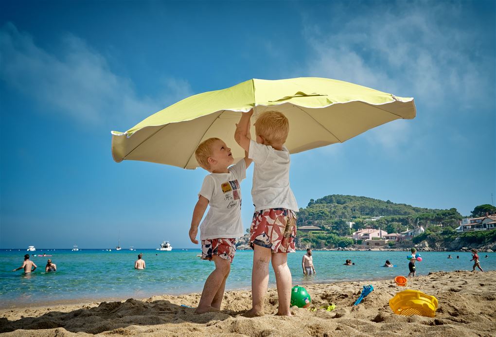 to børn på stranden under paraply