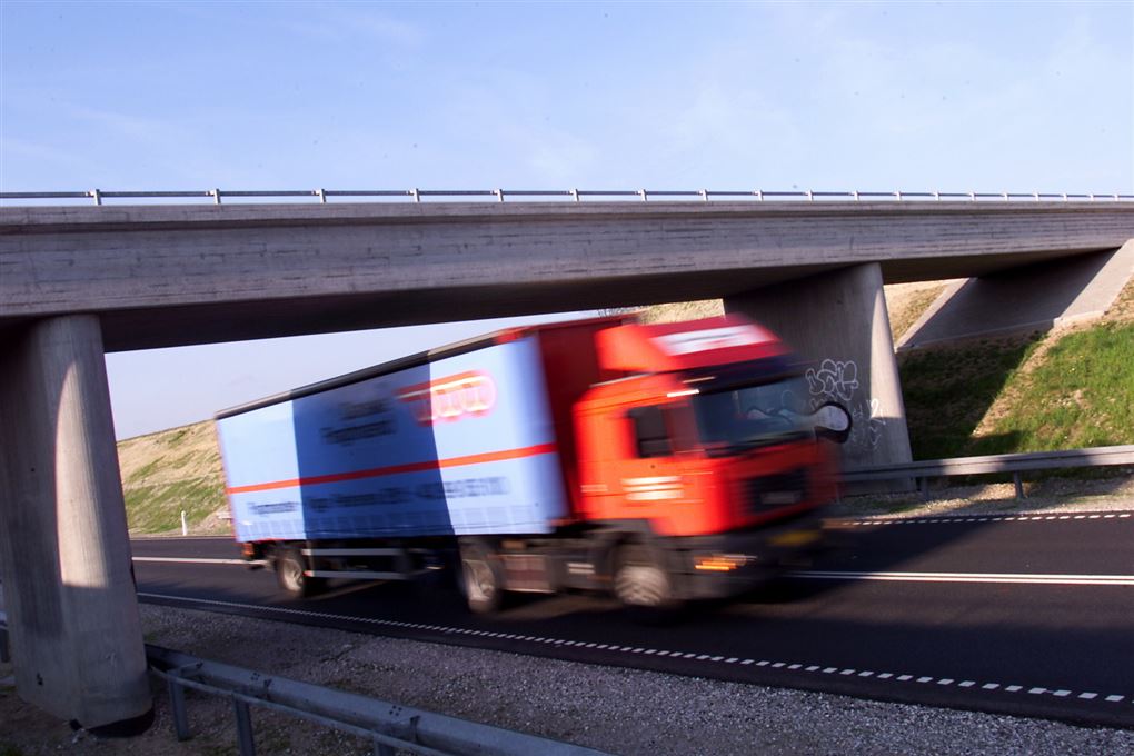Lastbil kører under motorvejsbro