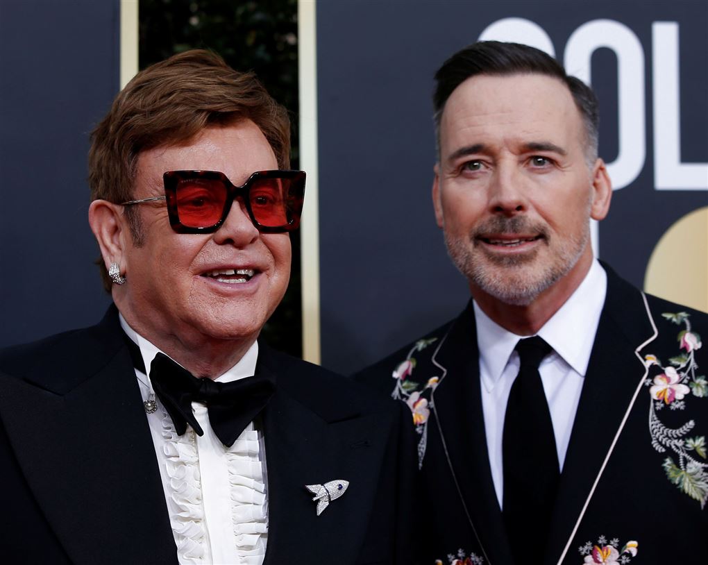 Elton John og David Furnish i jakkesæt smilende