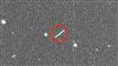 Et sort/hvidt billede af stjerner og en lysende streg, som udgør asteroiden.
