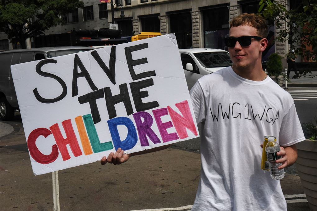 Tilhænger af konspirationsteorien QAnon med et skilt med påskriften "Save the Children"