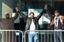 Tre mænd står med armene i vejret uden for retsbygning i New Zealand