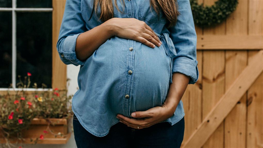 gravid kvinde holder om sin mave