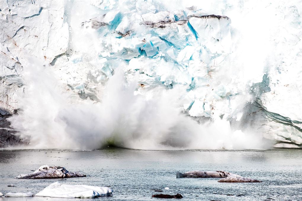 Store stykker is ryger ned i vandet fra en gletsjer