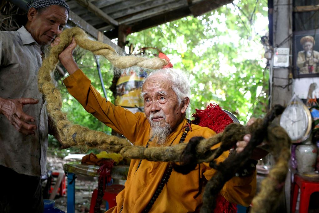 Den 92-årige Nguyen Van Chien sidder med en del af sit fem meter lange hår i hænderne.