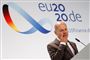 Tysklands finansminister, Olaf Scholz på en talerstol med et 20.de skilt bag sig