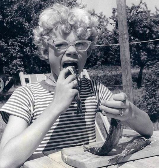 En pige med briller og krøller spiser rå sild