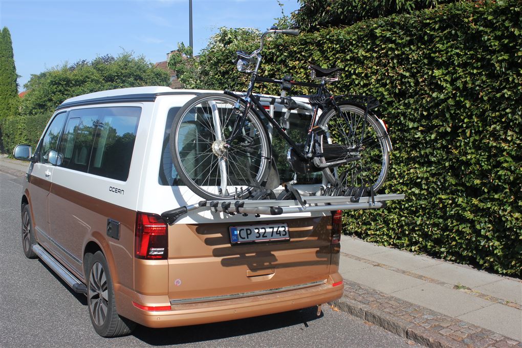 En autocamper bagfra med en cykel på