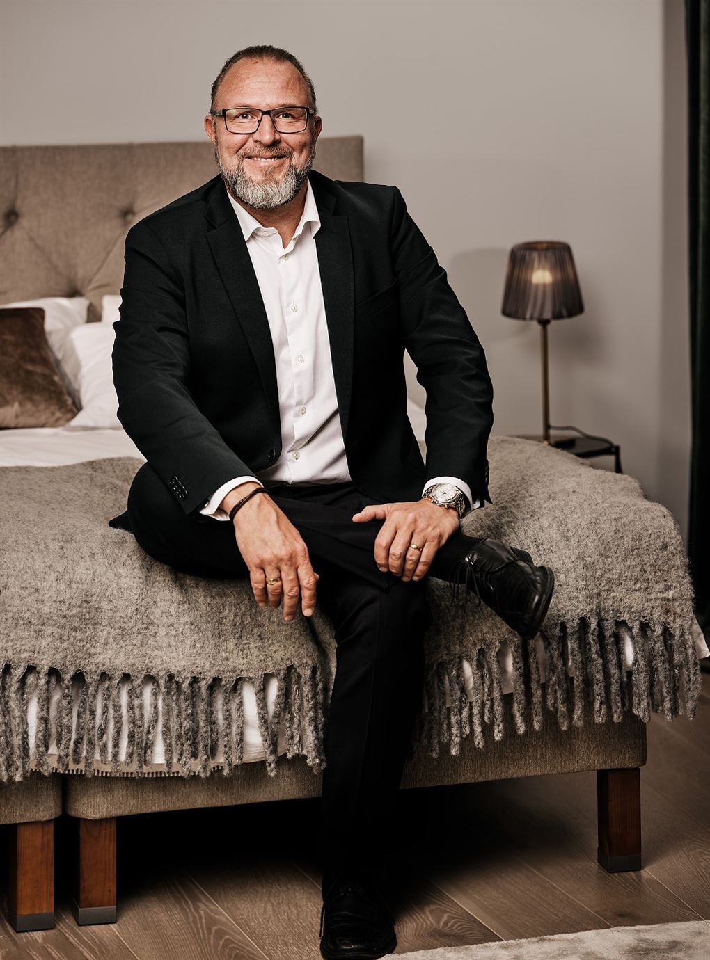 Grundlæggeren af YouBed Matias Sörensen sidder på en seng og smiler