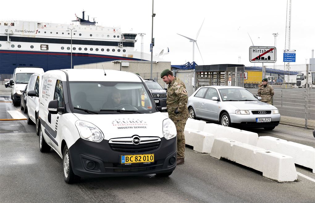 En uniformsklædt mand snakker med en bilist ved færgelejet i Hirtshals.