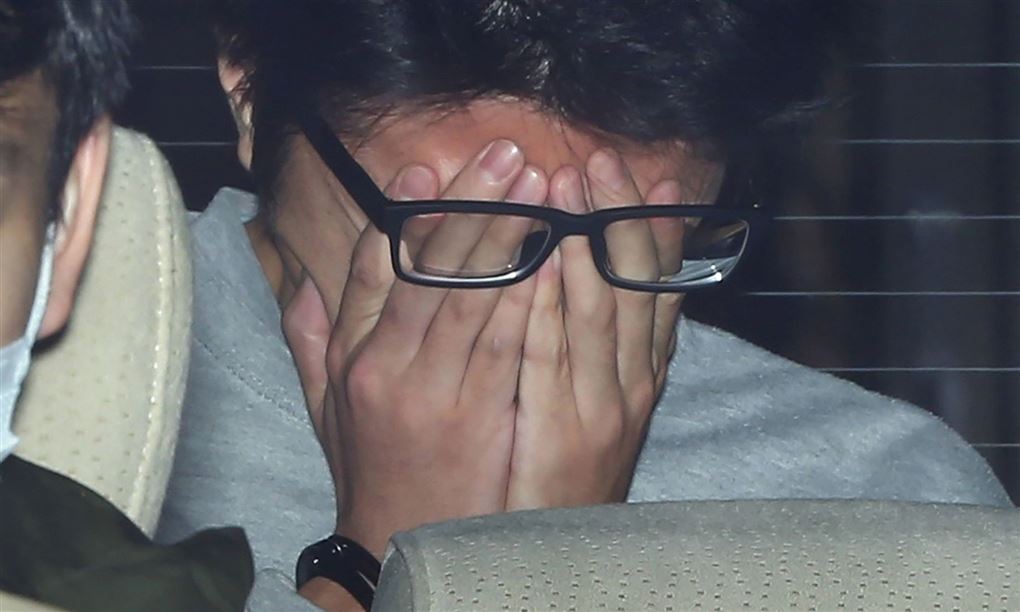Takahiro Shiraishi skjuler sit ansigt bag sine hænder