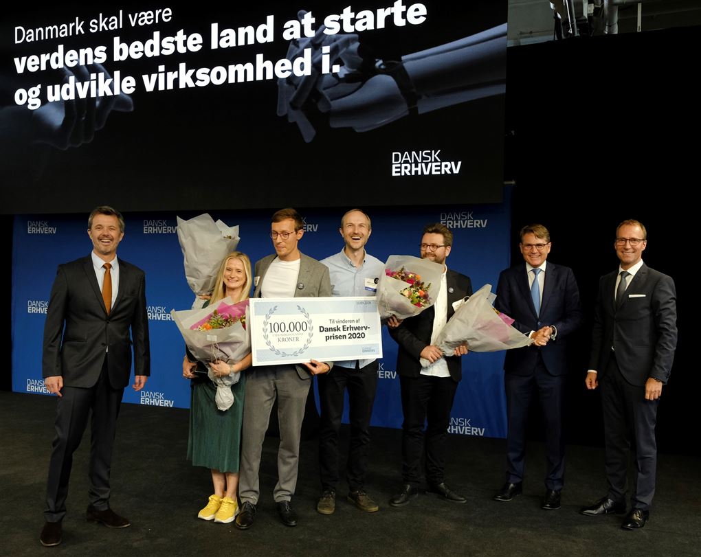 Kronprinsen står med kvinder og mænd på scenen.