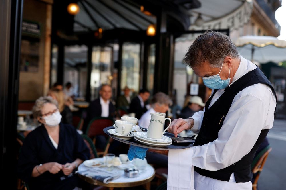 Tjener med mundbind på cafe i Paris