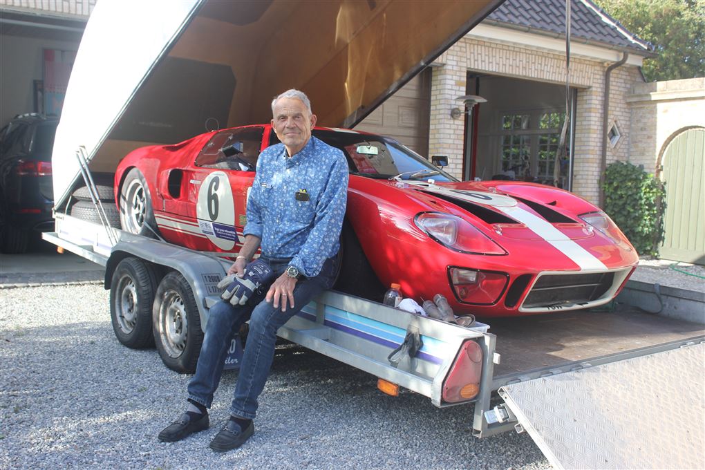 Karsten Ree sidder på en trailer, hvor de står en rød Ford GT40 på.