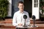 Politikeren Jesper Andersen iført hvid skjorte står ved en udendørs talerstol med to mikrofoner med vindhætter på.