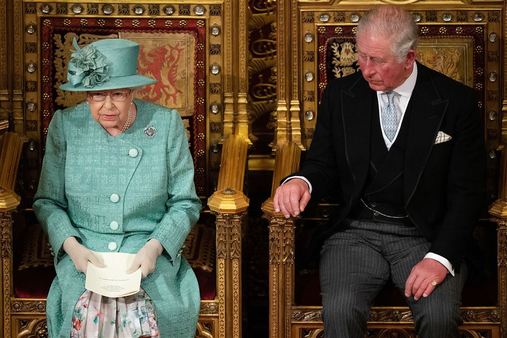 Dronning Elizabeth på en trone med sin søn Charles ved siden af