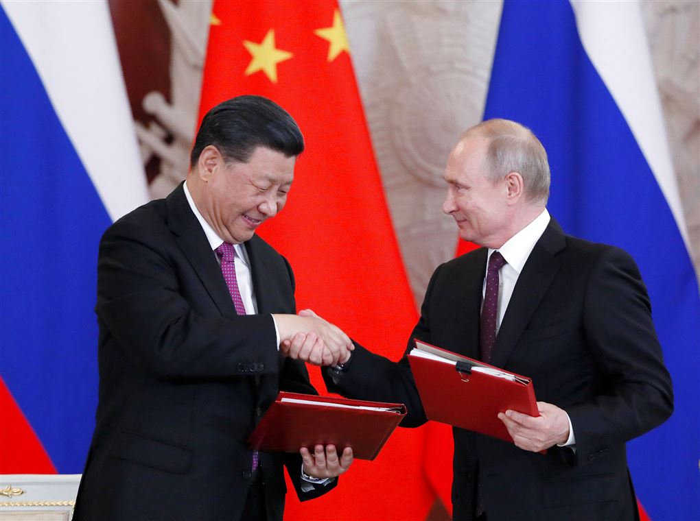 Præsidenterne Ji Xinping og Vladimir Putin giver hinanden et håndtryk