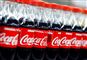 Mange flasker coca-cola med den ikoniske røde etikette med hvide bogstaver. 