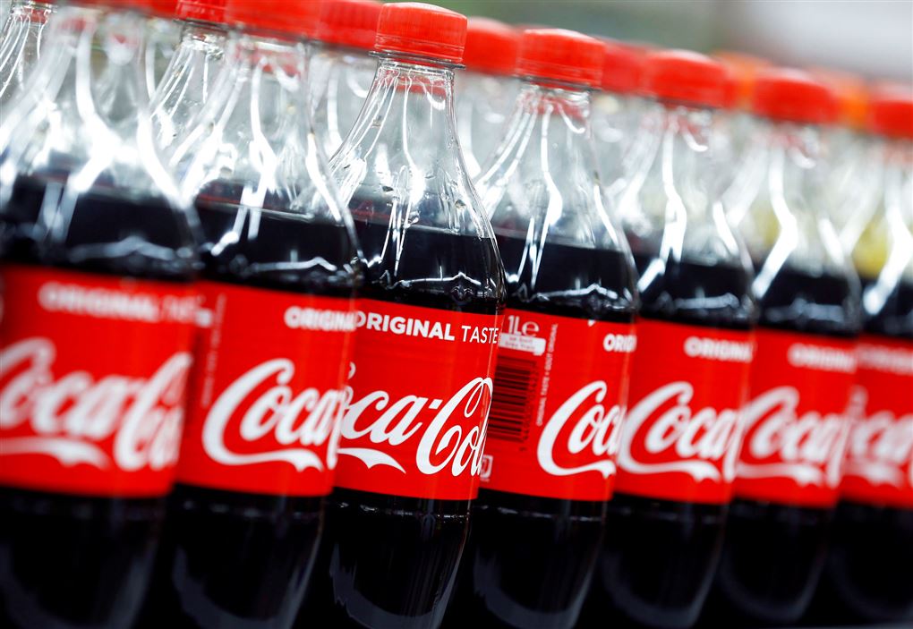 Mange flasker coca-cola med den ikoniske røde etikette med hvide bogstaver. 
