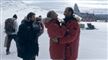 to personer i røde jakker omfavner hinanden på Sydpolen
